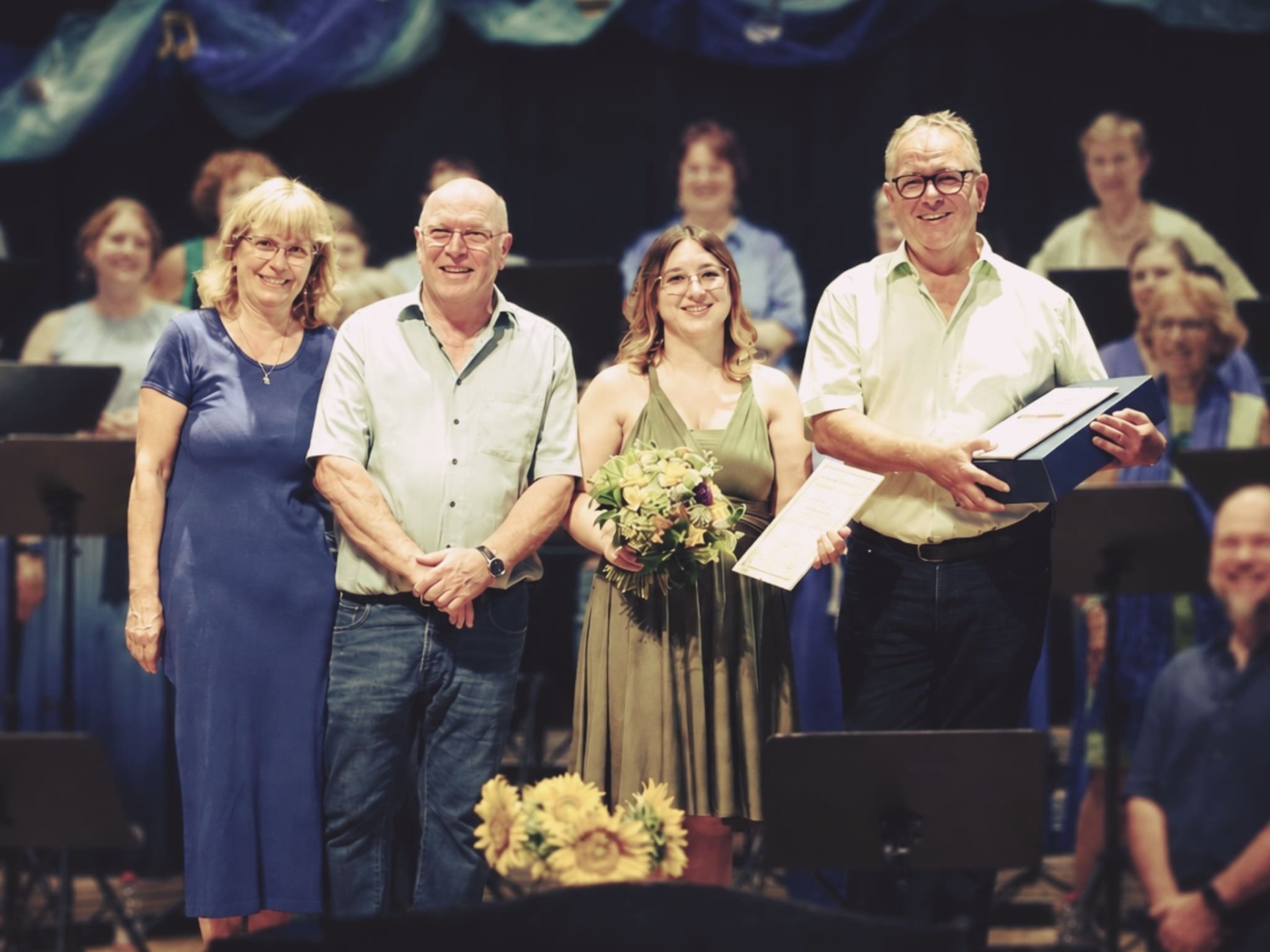 Doris Magnani, Lothar Sigloch, Leslie Bayer und Hansi Fingerle stehen nebeneinander bei einer Ehrung. Ausgezeichnet werden 40 Jahre Chorleitung sowie 20 beziehungsweise 50 Jahre aktives Singen.